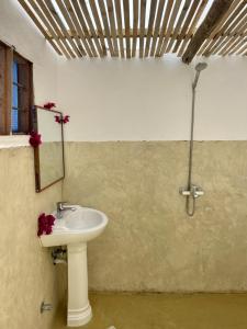 y baño con lavabo y espejo. en Mwananchi Bungalows, en Paje