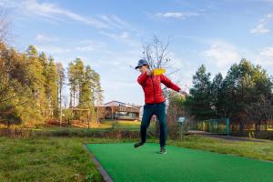 Un homme saute dans l'air pour attraper un frisbee dans l'établissement Tõrva Veemõnula Spaahotell, à Tõrva