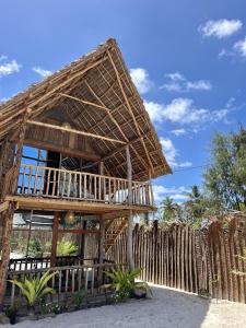 a bamboo building with a fence in front of it at Mwananchi Bungalows in Paje