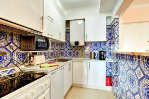 a kitchen with blue and white tiles on the wall at PORTUGAL HOLIDAYS in Luz
