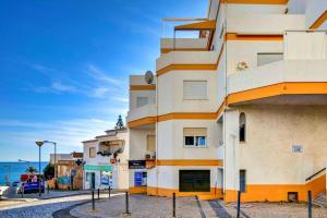 ein Gebäude auf einer Straße neben dem Meer in der Unterkunft PORTUGAL HOLIDAYS in Luz