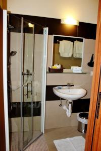 uma casa de banho com uma cabina de duche em vidro e um lavatório. em Hotel Le Nereidi em Cervo