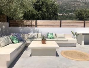 a patio with couches and a coffee table on a patio at Diosas Luxury Villas in Pilaroú