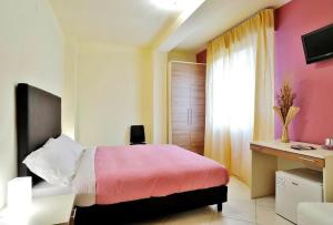 um quarto com uma cama, uma secretária e uma janela em Hotel Le Nereidi em Cervo