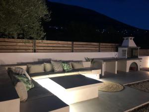 a patio with a couch and a table at night at Diosas Luxury Villas in Pilaroú