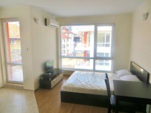um quarto com uma cama, uma secretária e uma janela em Apartments in Azalia 2 Complex em Nessebar