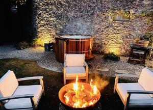uma fogueira com cadeiras e uma banheira de hidromassagem em St Anne's Manor - Luxury Villa with Hot Tub em Torquay