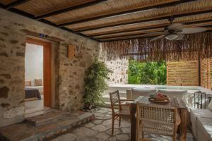 a dining room with a table and a ceiling fan at Ultava Houses in Datca
