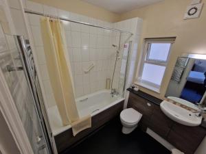 a bathroom with a shower, toilet and sink at Grange Lodge Hotel in Saint Peter Port