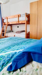 LILLI'S HOME Appartamento confortevole vicino ad Asiago في روانا: غرفة نوم بسريرين بطابقين مع ملاءات زرقاء