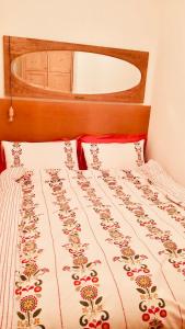 - un lit avec un couvre-lit et des fleurs dans l'établissement LILLI'S HOME Appartamento confortevole vicino ad Asiago, à Roana