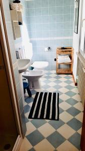 La salle de bains est pourvue d'un lavabo et de toilettes. dans l'établissement LILLI'S HOME Appartamento confortevole vicino ad Asiago, à Roana