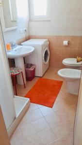 La salle de bains est pourvue d'un lavabo et d'un lave-linge. dans l'établissement LILLI'S HOME Appartamento confortevole vicino ad Asiago, à Roana