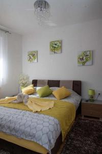 a bedroom with a large bed with yellow sheets at Apartments Oaza in Daruvar