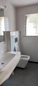 a white bathroom with a sink and a toilet at Apani Dhani Eco-Lodge in Nawalgarh