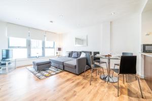 a living room with a couch and a table at Liverpool St Shoreditch London Terrace Apartment in London