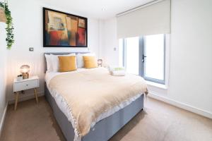 una camera bianca con un grande letto con cuscini gialli di Liverpool St Shoreditch London Terrace Apartment a Londra