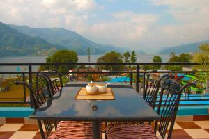 a blue table with two cups on top of a balcony at Hotel Adam in Pokhara