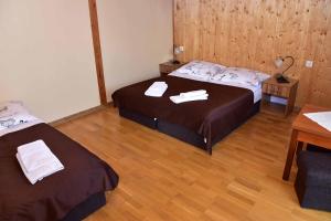 two beds in a room with wooden floors at Nad Stawem in Powidz