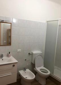 Baño blanco con aseo y lavamanos en SAN FELICE ROOMS en Bolonia