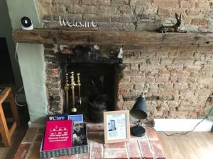 una chimenea de ladrillo con un cartel que diga bienvenida en Almond Cottage Clare - 2 bedroom English Cottage, en Clare