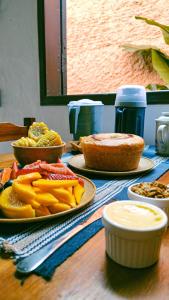 una mesa cubierta con platos de comida en una mesa en Tiwá Hostel - antigo DaSanta - CENTRO, en Arraial d'Ajuda