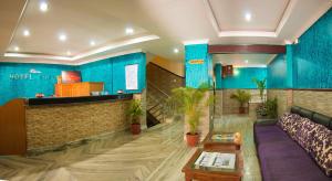a lobby with blue walls and a couch and tables at Hotel Adam in Pokhara