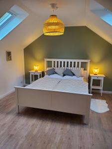 ein Schlafzimmer mit einem großen weißen Bett mit zwei Tischen in der Unterkunft Familienfreundliche Ferienwohnung Soltau in Soltau