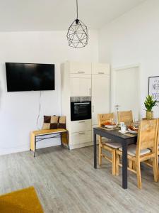 a living room with a table and chairs and a tv at Aurum Apartment in Kirchheim am Neckar