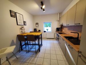 eine Küche mit einem Tisch, Stühlen und einem Waschbecken in der Unterkunft Familienfreundliche Ferienwohnung Soltau in Soltau