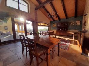 comedor grande con mesa de madera y sillas en Rosso Di Sera, en Novello