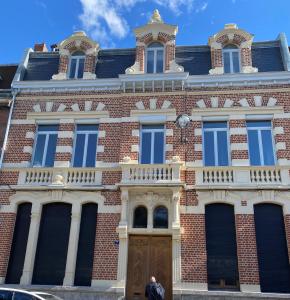 een man die voor een bakstenen gebouw staat bij Maison Mimerel Colodge in Roubaix