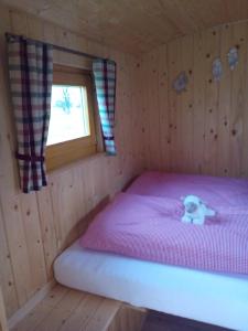 ein Teddybär auf einem Bett in einer Hütte in der Unterkunft Hof Gruebler in Klipphausen