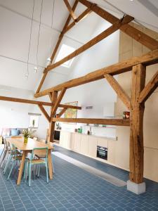 una cucina e una sala da pranzo con travi in legno di Origineel gerenoveerde schuur nabij Antwerpen a Zoersel