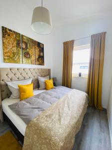 ein Schlafzimmer mit einem großen Bett mit gelben Kissen in der Unterkunft Aurum Apartment in Kirchheim am Neckar