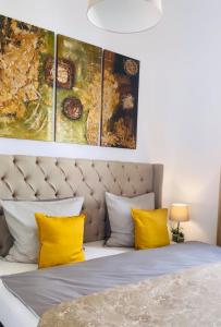 Aurum Apartment في Kirchheim am Neckar: غرفة نوم بسرير مع مخدات صفراء