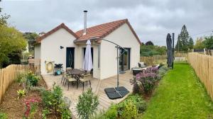 a small white house with a wooden deck in a garden at Proche centre ville, gîte 4 étoiles avec piscine in Dijon