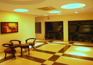 una habitación con 2 sillas y una planta de tablero de ajedrez en Hotel Aristos Boutique & Suites, en Chittagong 10 fotos más