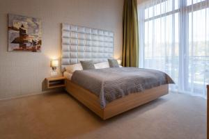 una camera da letto con un letto grande e una grande finestra di TATRYSTAY Private Apartments Hrebienok a Starý Smokovec