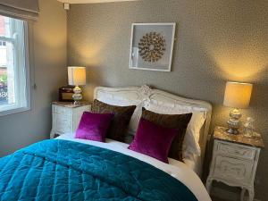 a bedroom with a blue and white bed with purple pillows at Coppergate Apartments in York