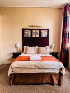 un grande letto in una camera da letto con due lampade di The Gold Hut a Johannesburg