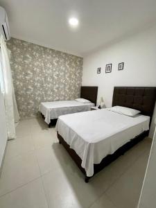 a bedroom with two beds and a wall at Edificio Las Palmas 3100 in Santa Cruz de la Sierra