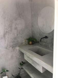a bathroom with a concrete sink and a mirror at Casa sossegada ao lado da natureza e do mar in São Sebastião