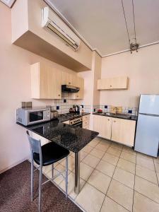 uma cozinha com uma mesa e um frigorífico em The Gold Hut em Joanesburgo