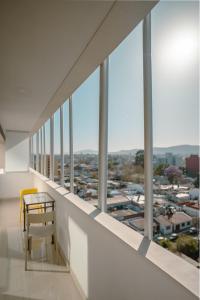 d'un balcon avec une table et une chaise jaune. dans l'établissement Departamento con vista a las montañas + garage, à Salta