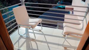 two white chairs sitting on a balcony at Hotel Amaranth in Dar es Salaam