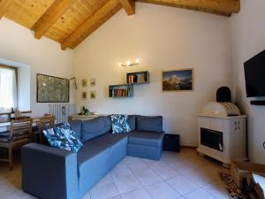 a living room with a blue couch and a table at Maso Daü in Marter di Roncegno