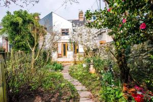 a garden with a stone path in front of a house at Gorgeous Victorian house sleeps 6 in Cardiff in Cardiff