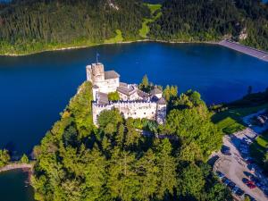 eine Insel inmitten eines Sees mit einem Schloss in der Unterkunft Pensjonat Szczepaniakówka in Burg Niedzica