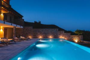 a swimming pool in a backyard at night at Hotel & Restaurant Pahor in Doberdò del Lago